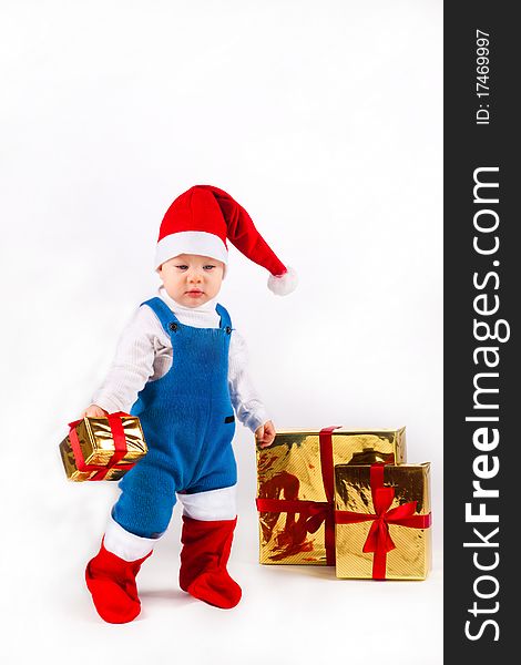 Little boy in Santa hat with a bunch of gifts