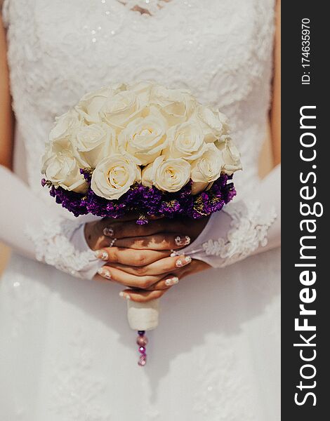 Bride holding bouquet in hands beautiful white