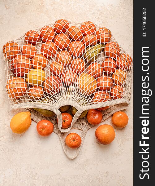 Cotton mesh shopping bag with fruit on background. Zero waste concept. Green, ecology