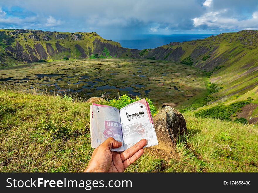 Showing passport with Rapa Nui stamp to Rano Kau volcano crater. Showing passport with Rapa Nui stamp to Rano Kau volcano crater