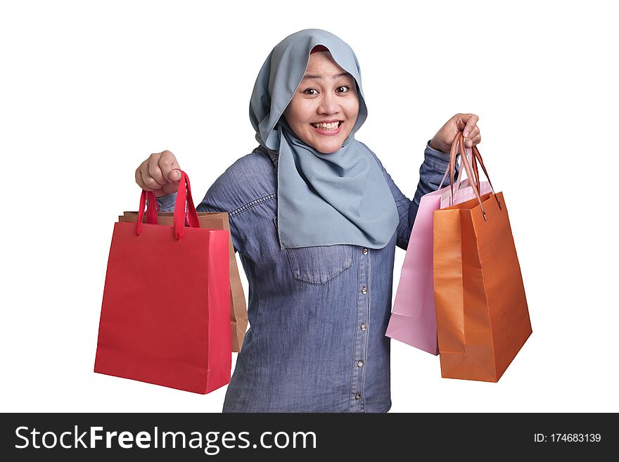 Portrait of happy Asian muslim woman brings shopping bags, isolated on white, consumerism lifestyle concept. Portrait of happy Asian muslim woman brings shopping bags, isolated on white, consumerism lifestyle concept
