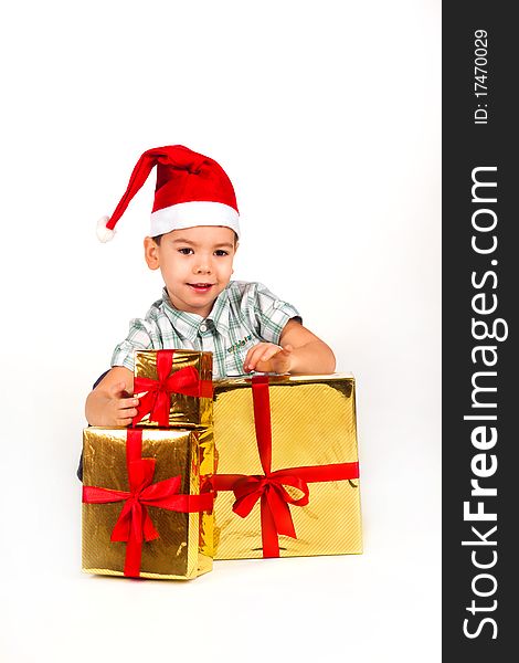 Happy little boy in Santa hat with a bunch of gifts, holiday Christmas, New Year