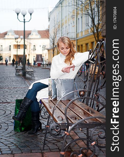 Only young woman sitting on a bench