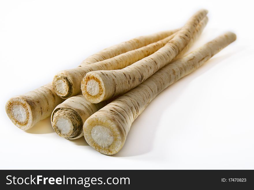 Sheaf of fresh parsnip isolarted on a white background. Focused on foreground. Sheaf of fresh parsnip isolarted on a white background. Focused on foreground.