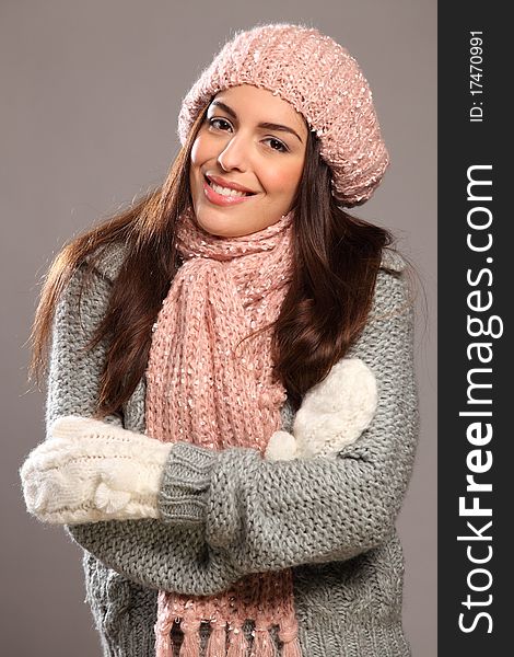 Portrait of a stunning young woman with long hair and big happy smile. Arms folded, wrapped up warm in winter woollies, including mits, hat, scarf and jumper. Portrait of a stunning young woman with long hair and big happy smile. Arms folded, wrapped up warm in winter woollies, including mits, hat, scarf and jumper.