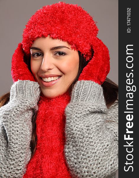 Cheerful portrait of a stunning young woman with long hair and big happy smile. Wrapped up warm in Christmas style winter woollies, including mits, hat, scarf and jumper. Cheerful portrait of a stunning young woman with long hair and big happy smile. Wrapped up warm in Christmas style winter woollies, including mits, hat, scarf and jumper.