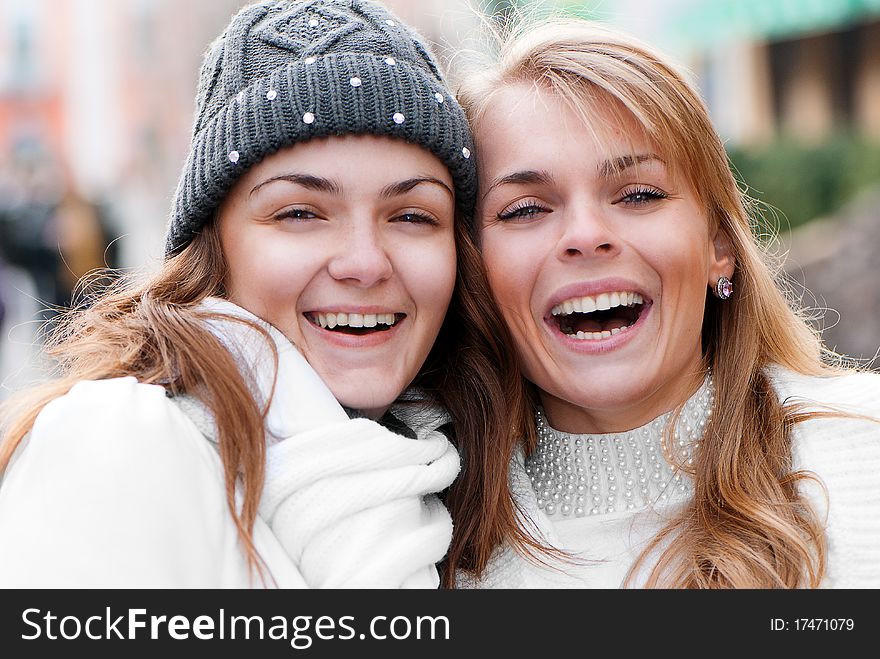 Two cheerful girls twins, in the street