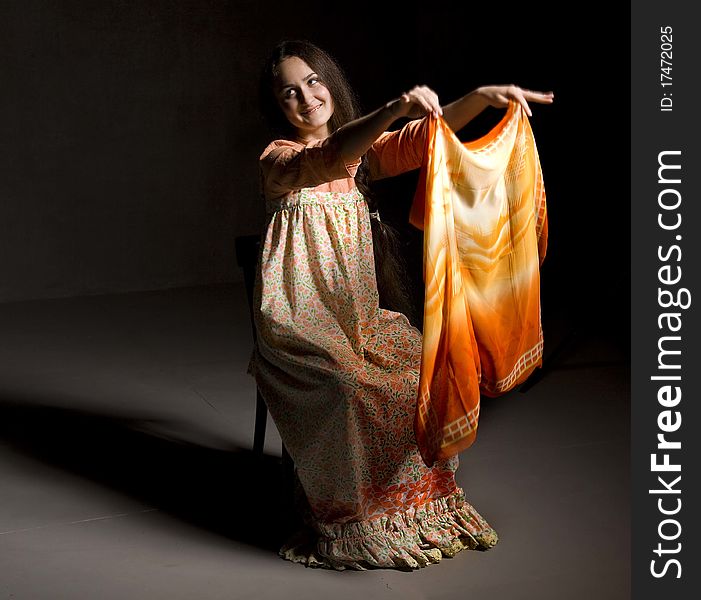 Portrait of beautiful young girl with a shawl. Ethnic russian dress. Taken in a studio setting. Black background. Portrait of beautiful young girl with a shawl. Ethnic russian dress. Taken in a studio setting. Black background.