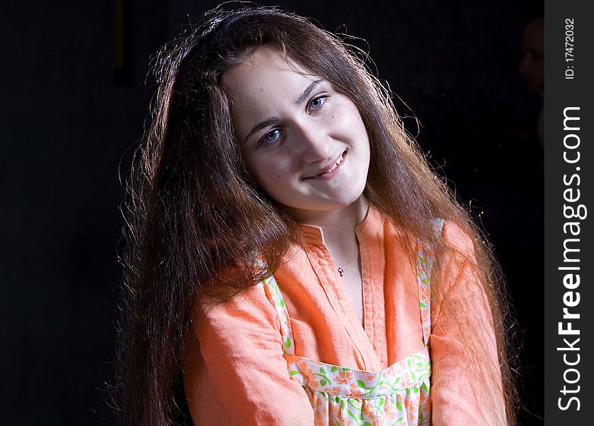 Portrait of a beautiful young girl with shining smile. Ethnic russian dress. Taken in a studio setting. Black background. Portrait of a beautiful young girl with shining smile. Ethnic russian dress. Taken in a studio setting. Black background.