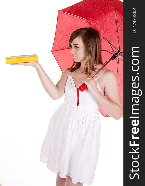 A woman under a red umbrella holding her yellow book out on her hand. A woman under a red umbrella holding her yellow book out on her hand.