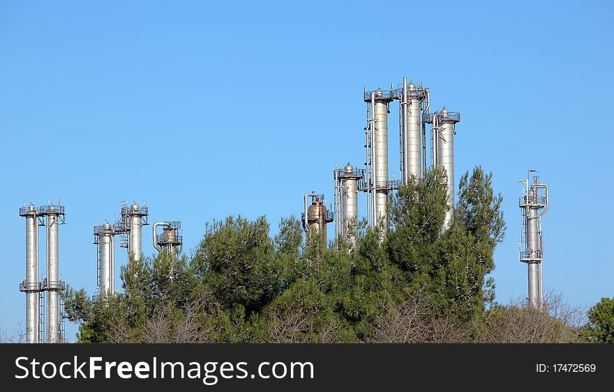 Many towers in an oil refinery over blue sky