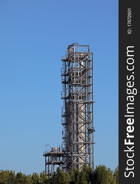 Tower in an oil refinery over blue sky. Tower in an oil refinery over blue sky