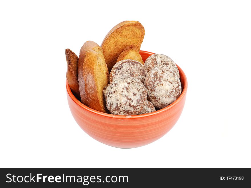 Bowl with crackers and spice-cakes on a white background