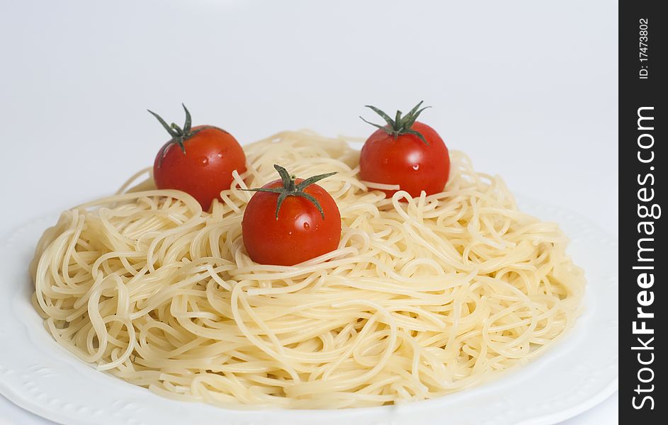 Plate of spaghetti with fresh tomatoes isolated on white background. Plate of spaghetti with fresh tomatoes isolated on white background