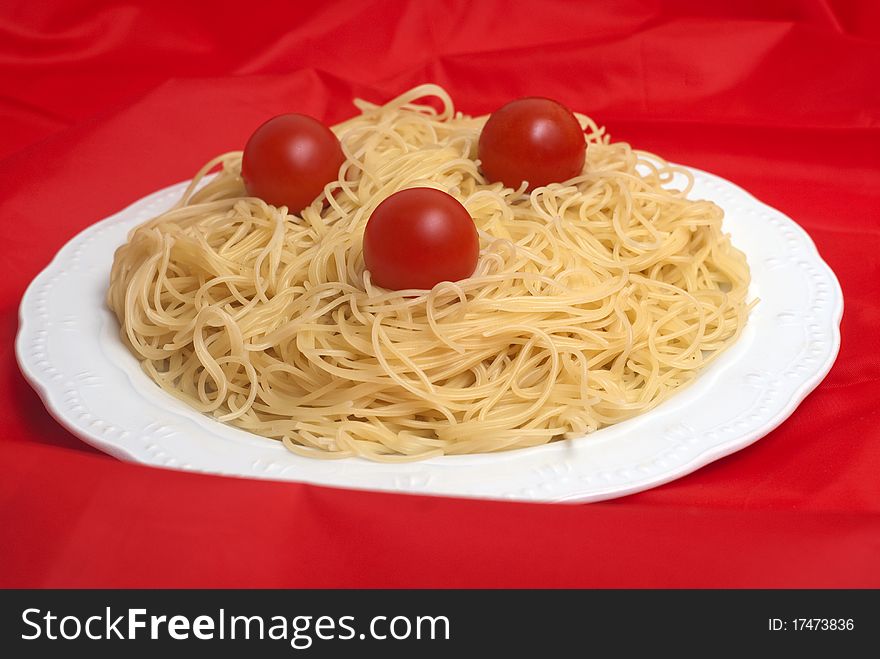 Plate of spaghetti with fresh tomatoes isolated on red background