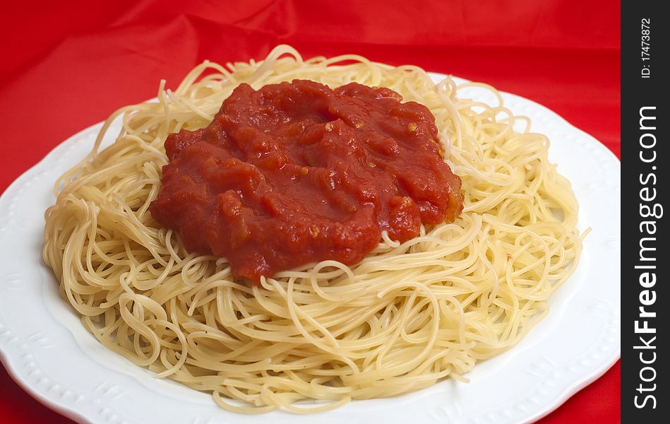 Plate of spaghetti with fresh tomatoes isolated on red background