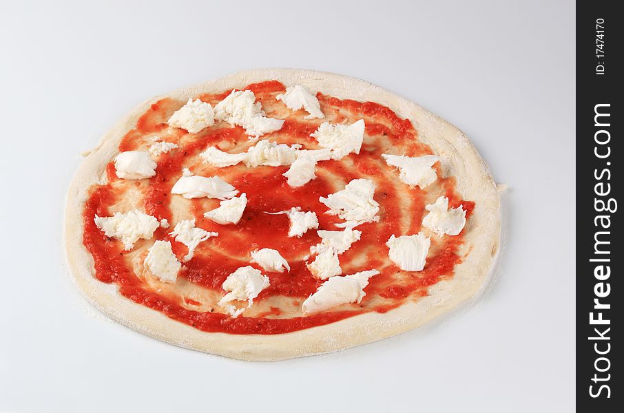 Tomato paste and mozzarella on raw pizza dough. Tomato paste and mozzarella on raw pizza dough