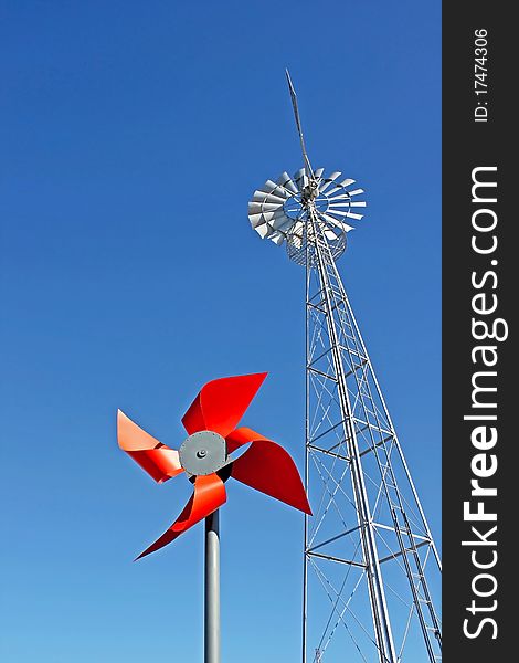 Two windmills with blue sky as background