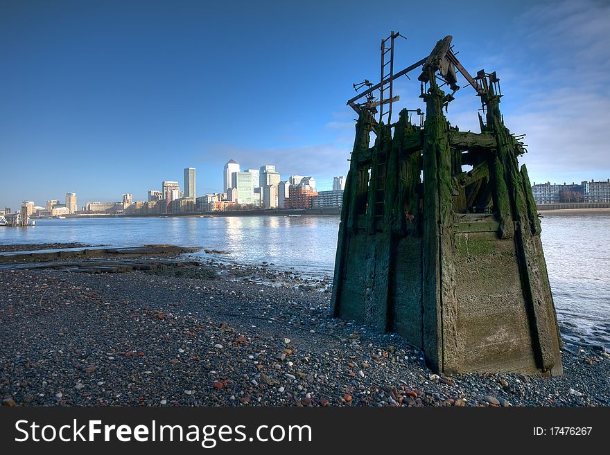 Low tide at the river Thames, Canary wharf business district skyline in a background, wide angle shot, subtle HDR. Low tide at the river Thames, Canary wharf business district skyline in a background, wide angle shot, subtle HDR