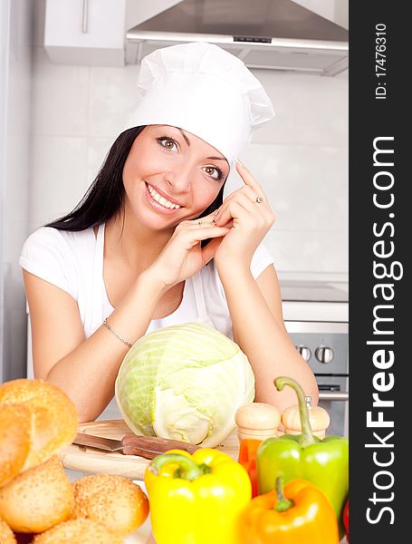 Beautiful young cook with  vegetables in the kitchen. Beautiful young cook with  vegetables in the kitchen