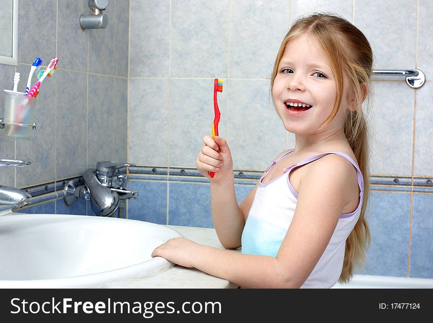 Little girl with toothbrush in the bathroom