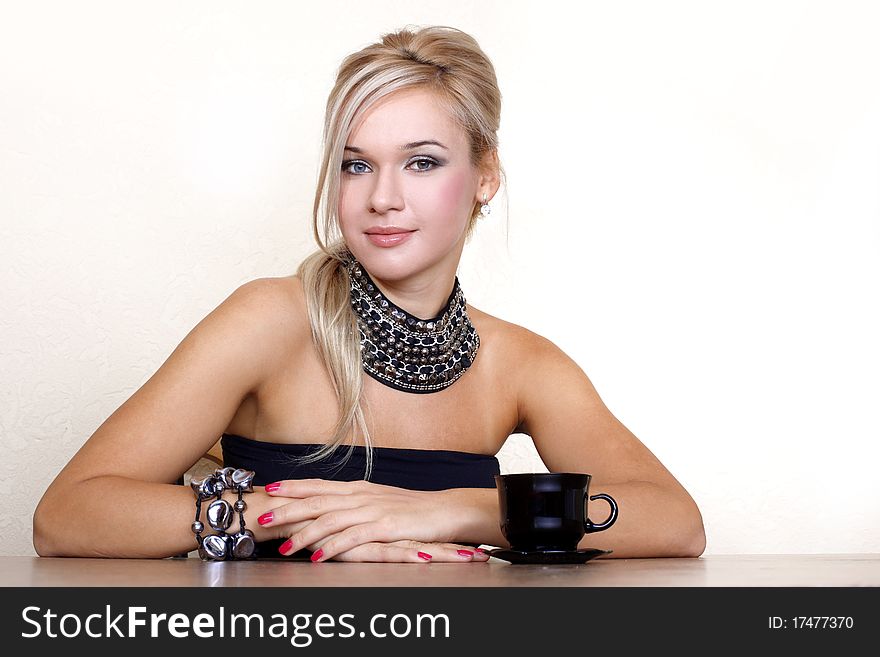 Woman with cup of hot drink against yellow wall at home