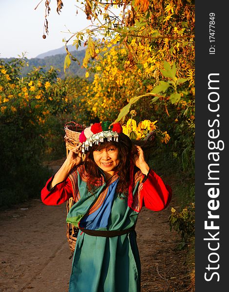 Lisu hill tribe woman in costume picking flowers