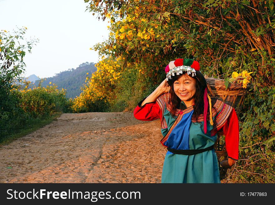 Lisu hill tribe woman in costume picking flowers