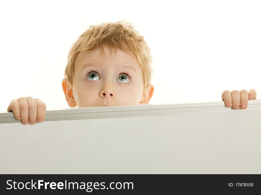 The little boy has control over a bulletin board and looks upwards. The little boy has control over a bulletin board and looks upwards