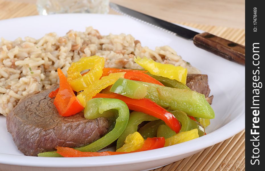 Steak dinner topped with peppers and rice. Steak dinner topped with peppers and rice