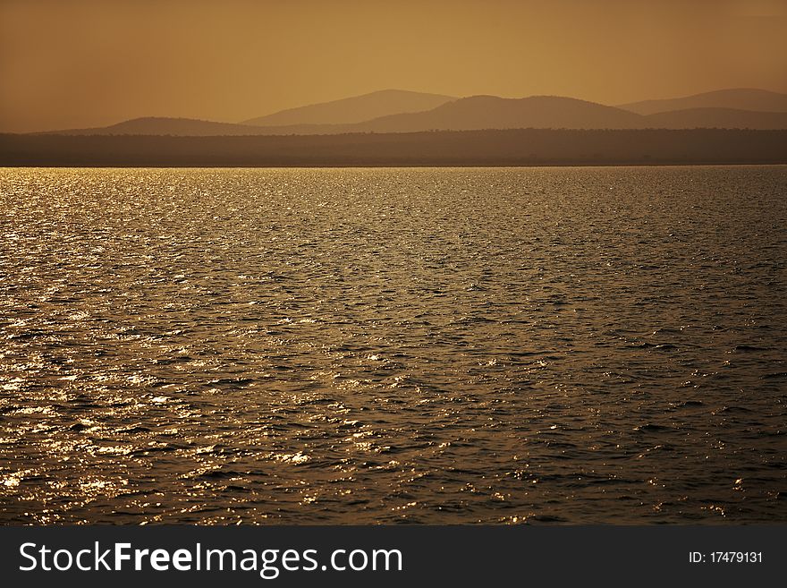 Sunset over a lake with misty hills. Sunset over a lake with misty hills