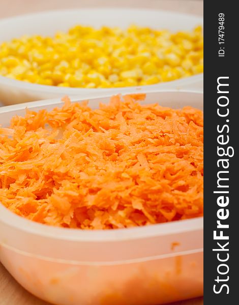 Carrot and corn separated in white bowls