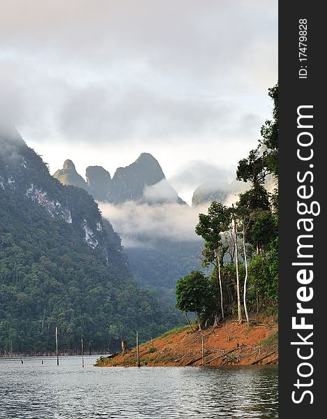 Beautiful lake view with limestone mountain and mist in morning.