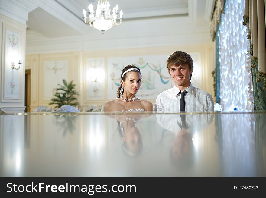 Happy bride and groom at the piano