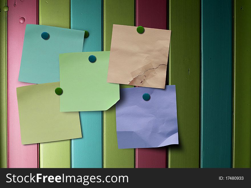 Multicolored notes over a multicolor painted wooden panel