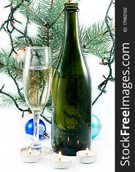 A bottle of champagne, glass, Christmas ornaments and Christmas tree twig. A bottle of champagne, glass, Christmas ornaments and Christmas tree twig