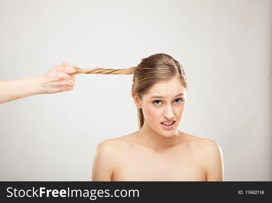 Hand is holding blond woman's hair. Hand is holding blond woman's hair