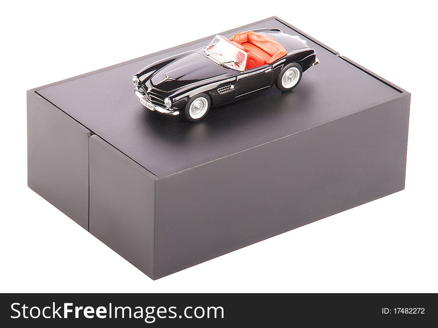 Black vintage toy car on a stand isolated on a white background