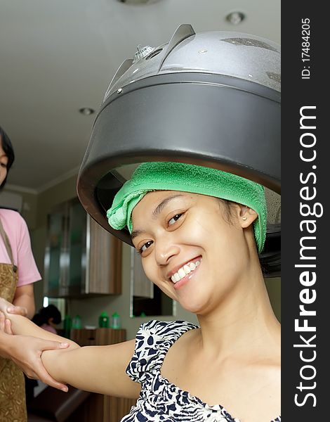 Asian ethnic young woman having hand massage by beautician at hair salon. Asian ethnic young woman having hand massage by beautician at hair salon