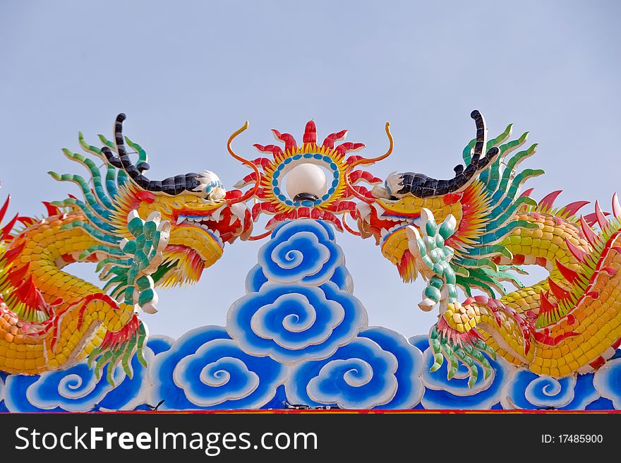 Two dragon statues in Chinese style on top of general temple roof. Two dragon statues in Chinese style on top of general temple roof.