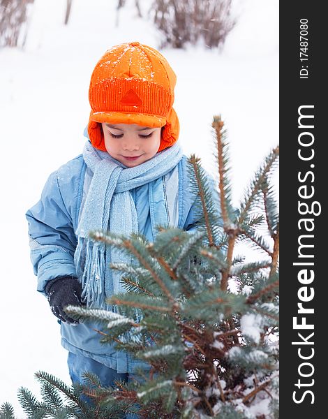 Little boy playing snowballs, snowman sculpts, digs snow. Holidays Christmas and New Year.