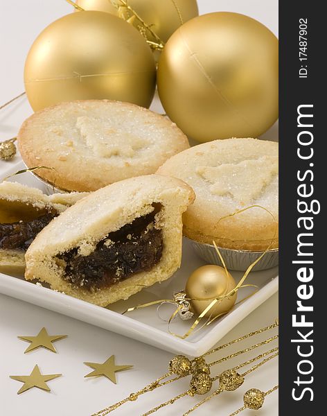 Homemade mince pies on white plate and Christmas ornaments. Homemade mince pies on white plate and Christmas ornaments.