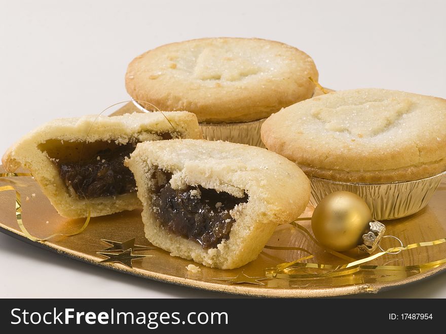 Homemade mince pies on golden plate and Christmas ornaments. Homemade mince pies on golden plate and Christmas ornaments.