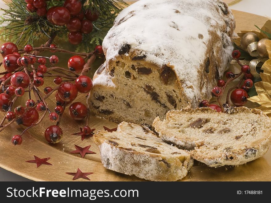 Traditional Christmas stollen filled with raisins served in a golden plate. Traditional Christmas stollen filled with raisins served in a golden plate.