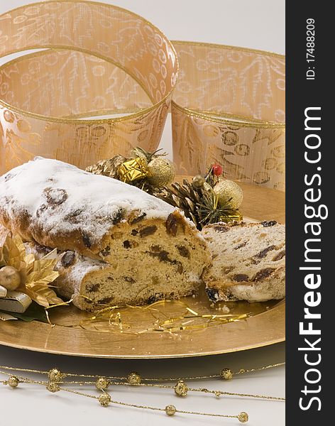Traditional Christmas stollen filled with raisins served in a golden plate. Traditional Christmas stollen filled with raisins served in a golden plate.