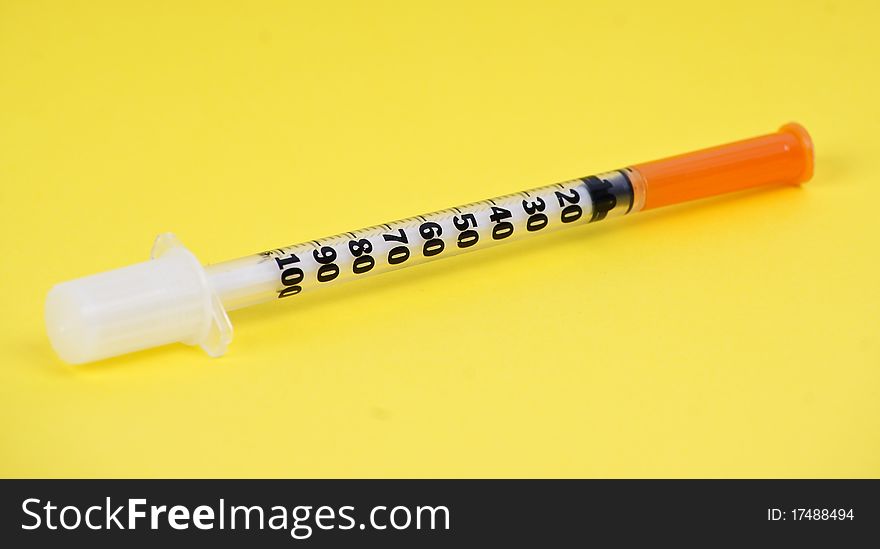 Plastic syringe on yelloy background