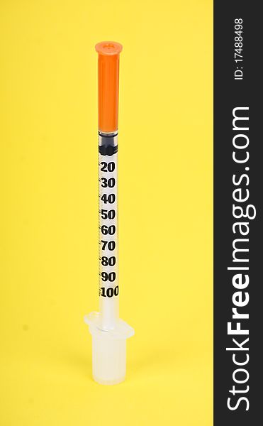 Plastic syringe on yelloy background