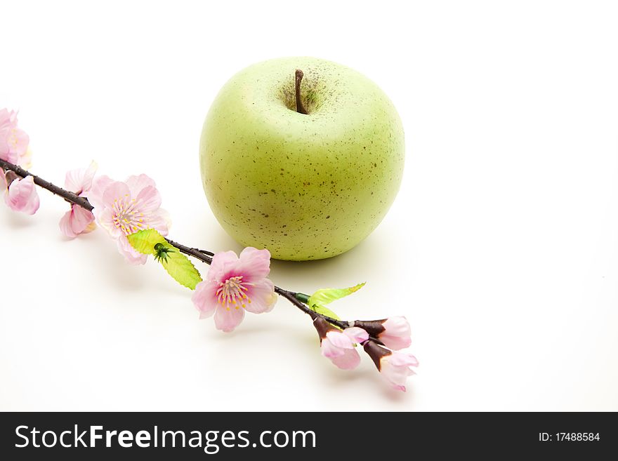 Green apple and branch with blossoms