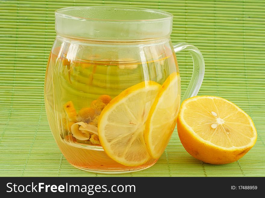 Green tea from herbs and lemon on a green background