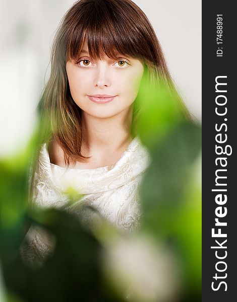 Beauty brunette in flowers, indoors